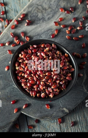 Rohe Bio Rubin Rot Popcorn in eine Schüssel geben Stockfoto