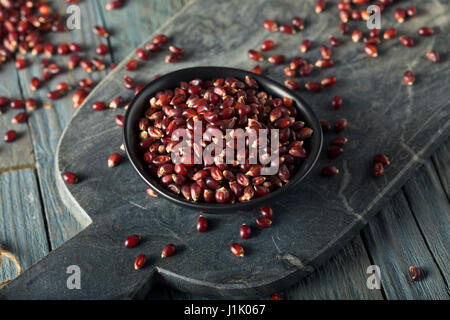 Rohe Bio Rubin Rot Popcorn in eine Schüssel geben Stockfoto