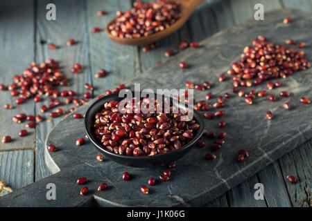 Rohe Bio Rubin Rot Popcorn in eine Schüssel geben Stockfoto