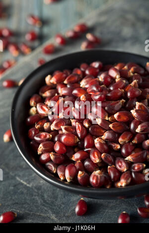 Rohe Bio Rubin Rot Popcorn in eine Schüssel geben Stockfoto