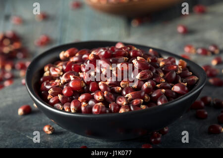 Rohe Bio Rubin Rot Popcorn in eine Schüssel geben Stockfoto