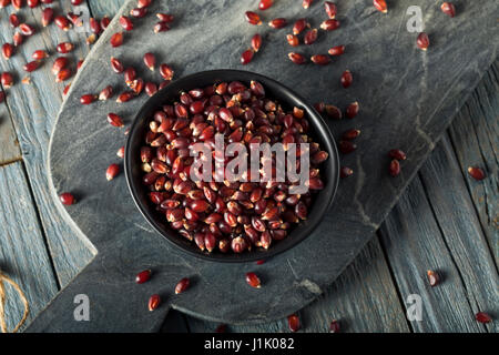 Rohe Bio Rubin Rot Popcorn in eine Schüssel geben Stockfoto