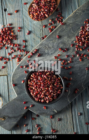 Rohe Bio Rubin Rot Popcorn in eine Schüssel geben Stockfoto