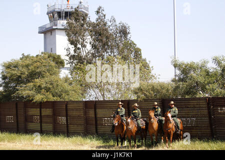 San Ysidro, Kalifornien, USA. 21. April 2017.  Die San Diego Bereich Customs and Border Protection Pferd Patrouille fuhr entlang der Grenze zu Mexiko vor einer Pressekonferenz mit Generalstaatsanwalt Jeff Sessions und Homeland Security Secretary John Kelly. Dahinter befindet sich die alte Grenzmauer und darüber hinaus, das Steuerelement für die Tijuana Rodriguez Flughafen tower. Bildnachweis: John Gastaldo/ZUMA Draht/Alamy Live-Nachrichten Stockfoto