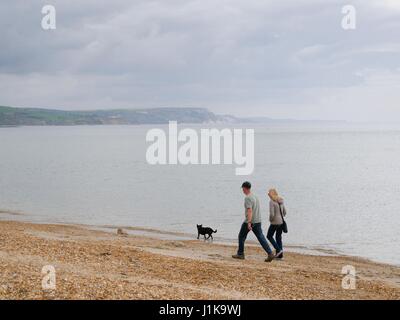 Weymouth, Dorset, UK. 22. April 2017. Zwei Menschen zu Fuß am Strand entlang an einem bewölkten, aber hellen Tag mit einer Temperatur von 13° C. © DTNews/Alamy Live Credit: Dan Tucker/Alamy Live-Nachrichten Stockfoto