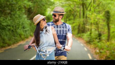 Digital Composite liebend Paar Reiten Fahrrad während der Sommerferien Stockfoto