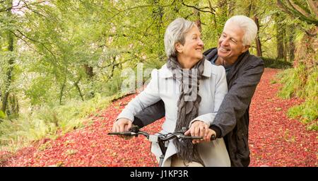 Digitalen Verbund aus senior Liebespaar Fahrrad im Wald Stockfoto