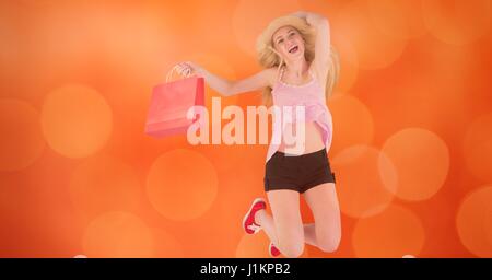 Digital Composite glücklich Frau mit Einkaufstasche springen über bokeh Stockfoto