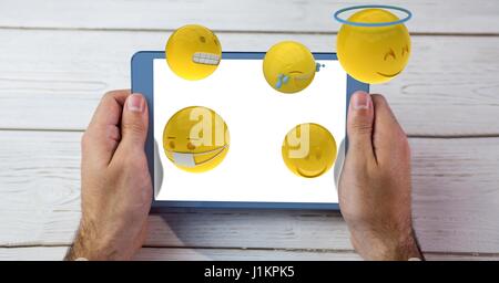 Digitalen Verbund aus Emojis flogen von Tablet-PC von Mann gehalten Stockfoto