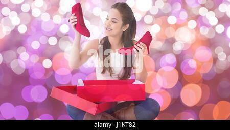 Digitalen Verbund aus glücklich Frau betrachten neue rote Schuhe über bokeh Stockfoto