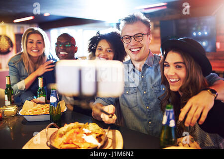 Horizontale Schuß von lächelnden Menschen, die eine selfie auf dem Smartphone in der Bar. Stockfoto