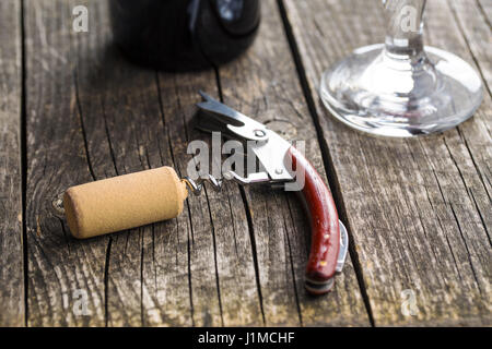Korkenzieher und Kork auf Holztisch. Stockfoto