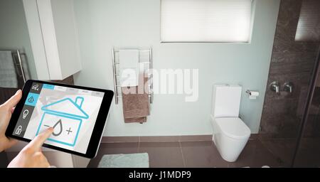 Digitalen Verbund von Hand mit smart home Anwendung auf digital-Tablette im Waschraum Stockfoto
