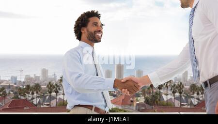 Digital Composite Geschäftsleute tun Handshake gegen city Stockfoto