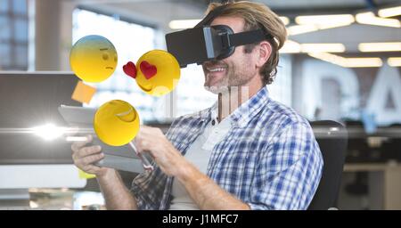 Digitalen Verbund aus glücklich Kaufmann mit VR-Brille und Tablet-PC während Emojis herumfliegen Stockfoto