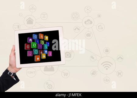 Digital Composite beschnitten Bild von Hand, die verschiedenen Symbole in digital-Tablette mit Symbolen im Hintergrund Stockfoto