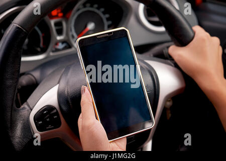Junge Fahrerin Touch Touchscreen-Smartphone und Gps-Navigation in einem Auto, Konzept mit Smartphone im Auto mit Nahaufnahme. Stockfoto
