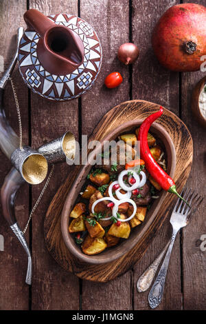 Ojaxuri, gebratenes Schweinefleisch und Kartoffeln mit Zwiebeln und Granatapfel Samen. Ansicht von oben Stockfoto