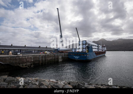 Großen Rotor Rotorblätter, die von einem Schiff im Hafen von Kyle of Lochalsh auf ein Teleskop Trailer zum Weitertransport auf der Straße entladen wird. Stockfoto