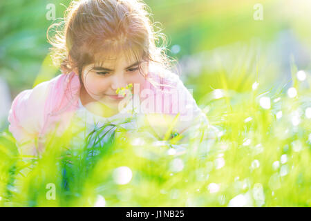 Porträt von ein wenig verträumt Mädchen Spaß in schöner sonniger Tag im Freien, genießen Aroma ein Blümchen auf dem Hinterhof Stockfoto