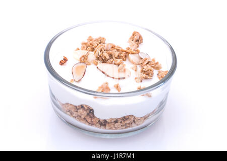 Joghurt mit Müsli in Glasschüssel auf weißem Hintergrund. Stockfoto