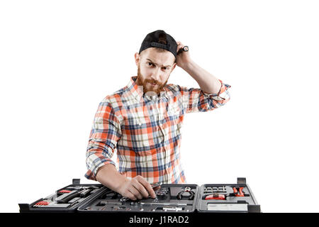 Rothaarige bärtiger Mann trägt einen Baseball-Cap und Shirt mit einem Schraubenschlüssel aus einer Toolbox vor ihm. Isoliert auf weiss. Wählen Sie zu machen. Denken. Stockfoto
