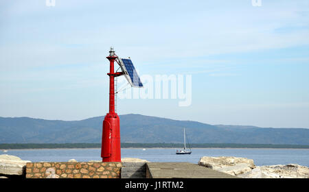 roten Leuchtturm mit Solar-Panel im Hafen Stockfoto