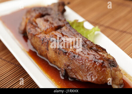 Gebratene Schweinerippchen auf weiße Scheibe Stockfoto