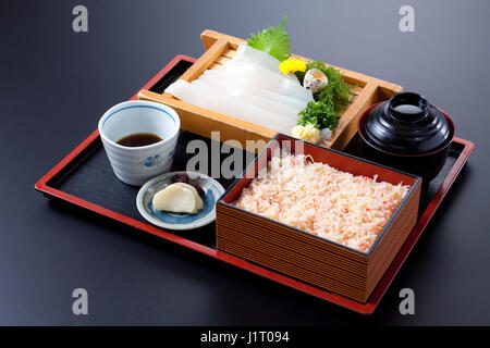 Bento von Tintenfisch Sushi und Reis auf schwarzem Hintergrund Stockfoto