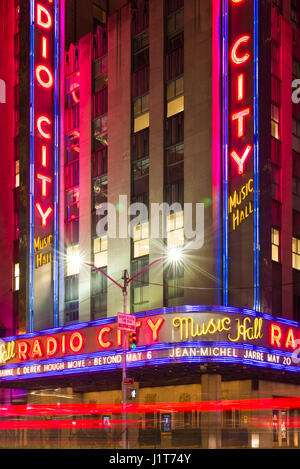 Die Radio City Music Hall bei Nacht mit dem Auto Licht Trails im Vordergrund, Manhattan, New York Stockfoto