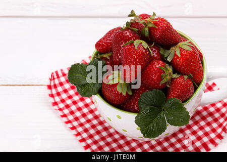 Rip frische Erdbeeren in einer Schüssel auf weißer Holztisch Stockfoto