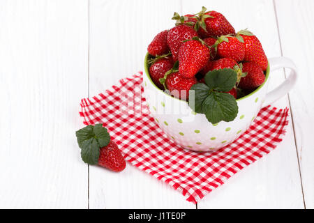 Rip frische Erdbeeren in einer Schüssel auf weißer Holztisch Stockfoto