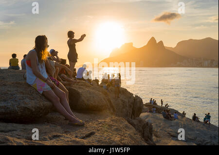 RIO DE JANEIRO - drängeln sich Menschen auf den Felsen am Arpoador für Position, um den Sonnenuntergang bei zwei Brüder Berg zu sehen: Stockfoto