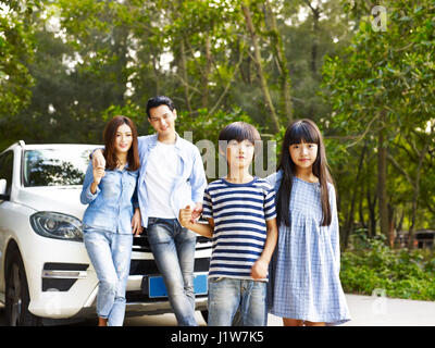 asiatischen Familie mit zwei Kindern, die mit dem Auto anreisen. Stockfoto