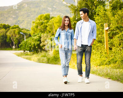 junge asiatische paar zu Fuß auf der Landstraße. Stockfoto