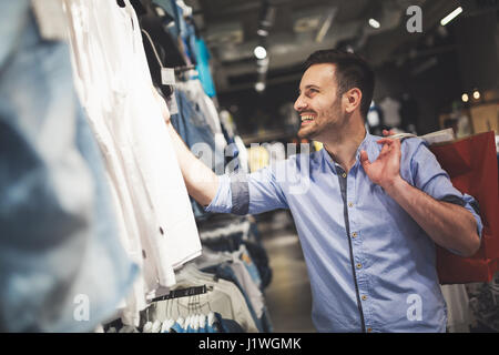 Hübscher Mann für neue Kleider im Shop einkaufen Stockfoto