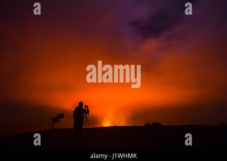 Ein Fotograf fängt die Rauch und Feuer aus dem Halemaʻumaʻu-Krater innerhalb der viel größeren Gipfel-Caldera des Kilauea-Vulkan in der Nacht in Hawaiʻi-Volcanoes-Nationalpark 6. November 2016 in Hilo, Hawaii. Stockfoto