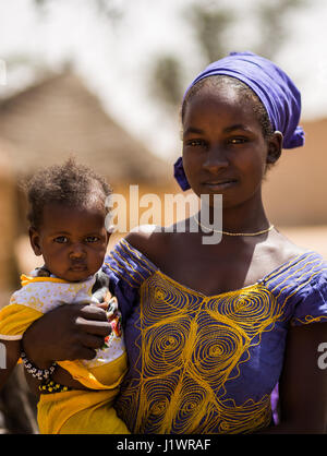 Fulani-Mädchen mit einem Baby aus einem ländlichen Dorf in Senegal Stockfoto