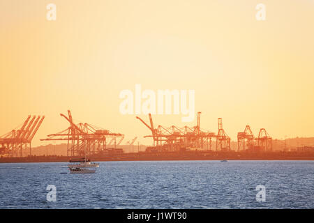 Long Beach Verschiffungshafen mit be-Cranes Silhouetten bei Sonnenuntergang, Kalifornien, USA Stockfoto