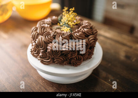 Frische Kuchen mit Schokolade Biskuit Creme, kulinarisches Meisterwerk, Nahaufnahme. Süßes Dessert auf hölzernen Hintergrund Stockfoto