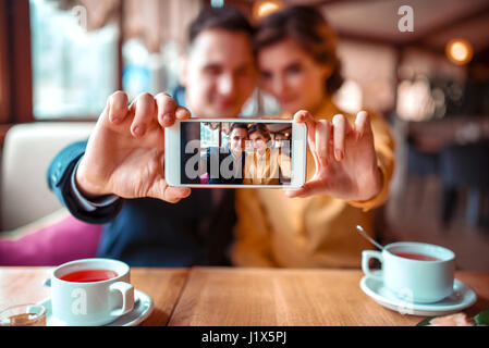 Liebespaar macht Selfie auf Handy-Kamera im Restaurant. Mann und Frau aus Feier Stockfoto