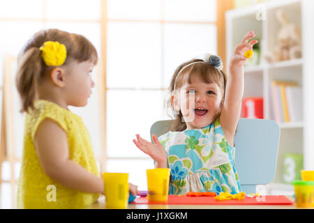 Kleine Kinder Spaß zusammen mit bunten Modelliermasse im Kindergarten. Kreative Kinder Formen zu Hause. Kinder Mädchen spielen mit Plastilin oder Teig. Stockfoto