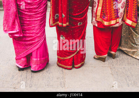 Drei Frauen in bunten Saris gekleidet. Abstrakte Komposition, die auf der Suche nach unten. Stockfoto