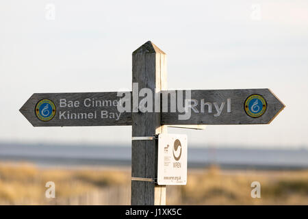 Hölzerne Strand Schild mit den Worten Rhyl und Bae Cinmel Kinmel Bay auf Teil des walisischen Küstenweg in den Badeort Rhyl in Nord-Wales Stockfoto