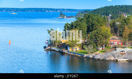 Schwedische ländliche Landschaft, Dorf an der Küste mit Holzhäuser, Scheunen und Leuchtturm Stockfoto