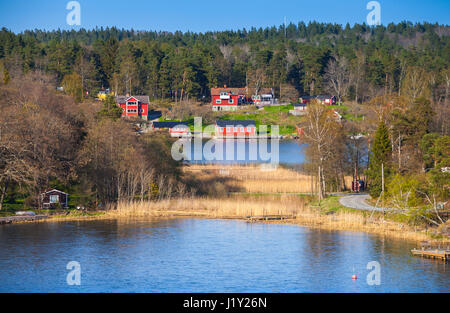 Schwedische ländliche Landschaft, Dorf an der Küste mit roten Holzhäusern Stockfoto