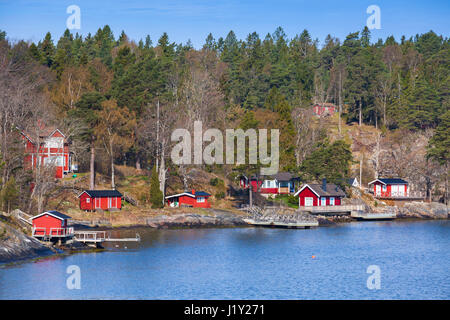 Schwedische ländliche Landschaft, Dorf an der Küste mit roten Holzhäusern und Scheunen Stockfoto