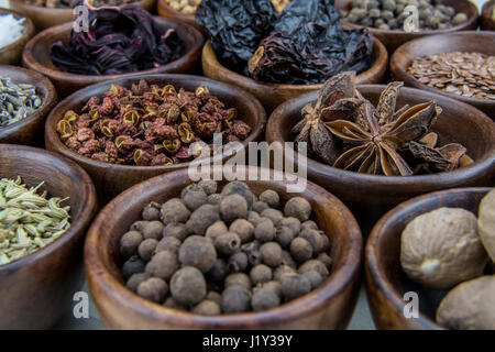 Szechuan-Pfefferkörner in Schüssel unter anderen vielfältigen Gewürzen Stockfoto