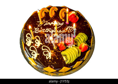 Happy Birthday Chocolate Cake isoliert auf weißem Hintergrund mit Früchten und brennenden Kerzen. Stockfoto
