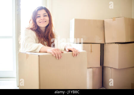 Lächelnde rothaarige Frau bewegt sich mit Boxen Stockfoto